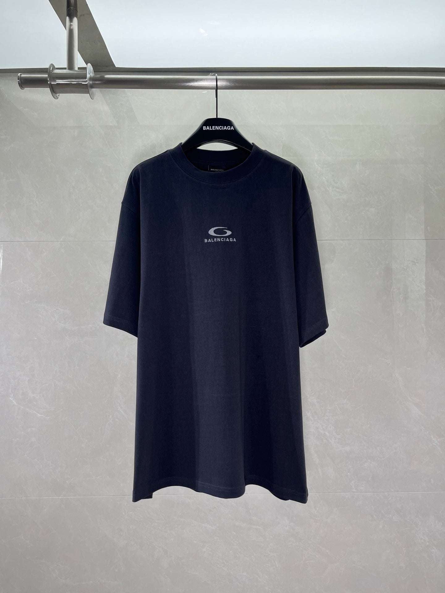 Navy short-sleeve crewneck T-shirt on hanger with BALENCIAGA logo at chest