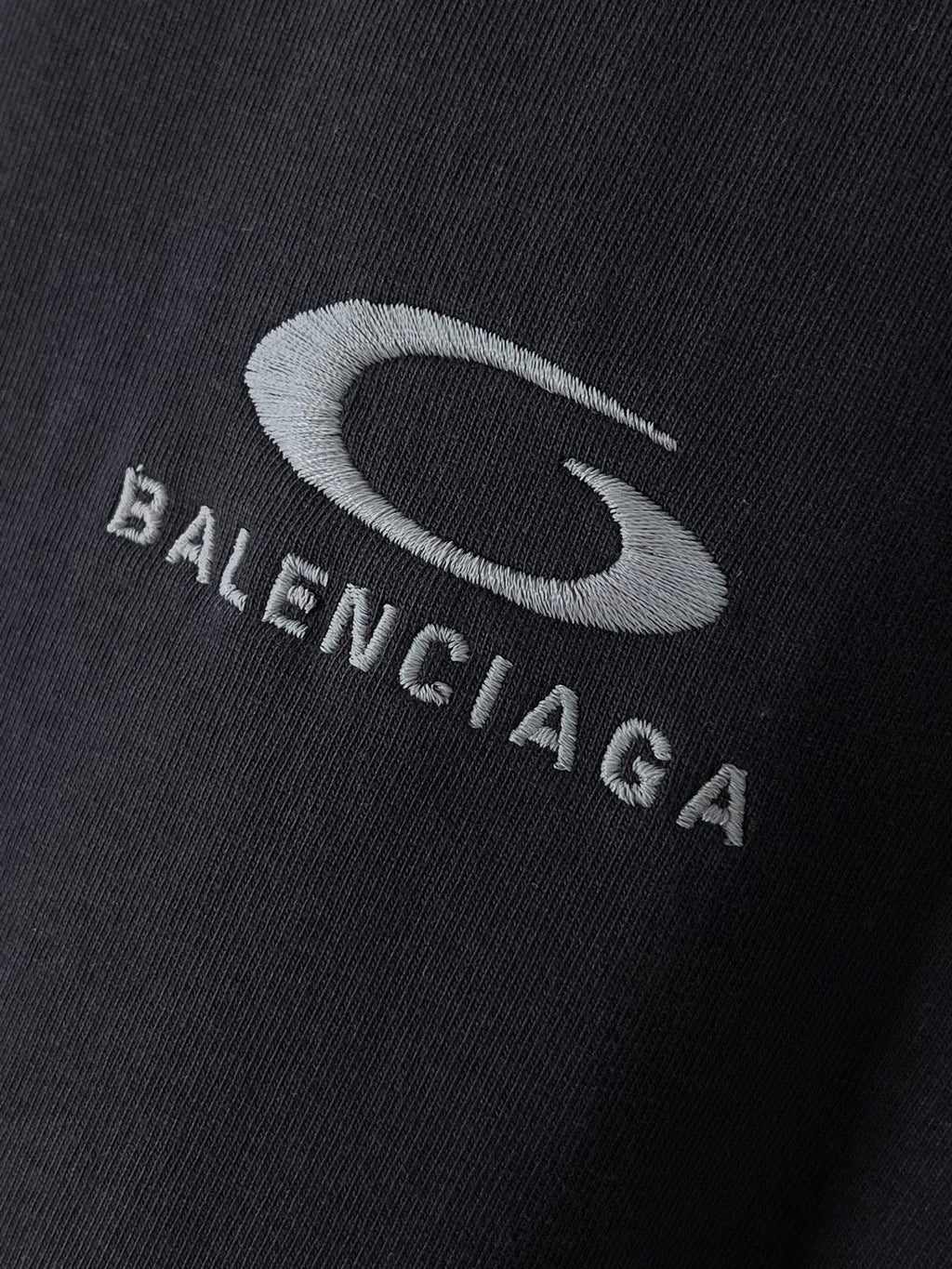 BALENCIAGA logo print on dark T-shirt fabric close-up