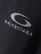 BALENCIAGA logo print on dark T-shirt fabric close-up