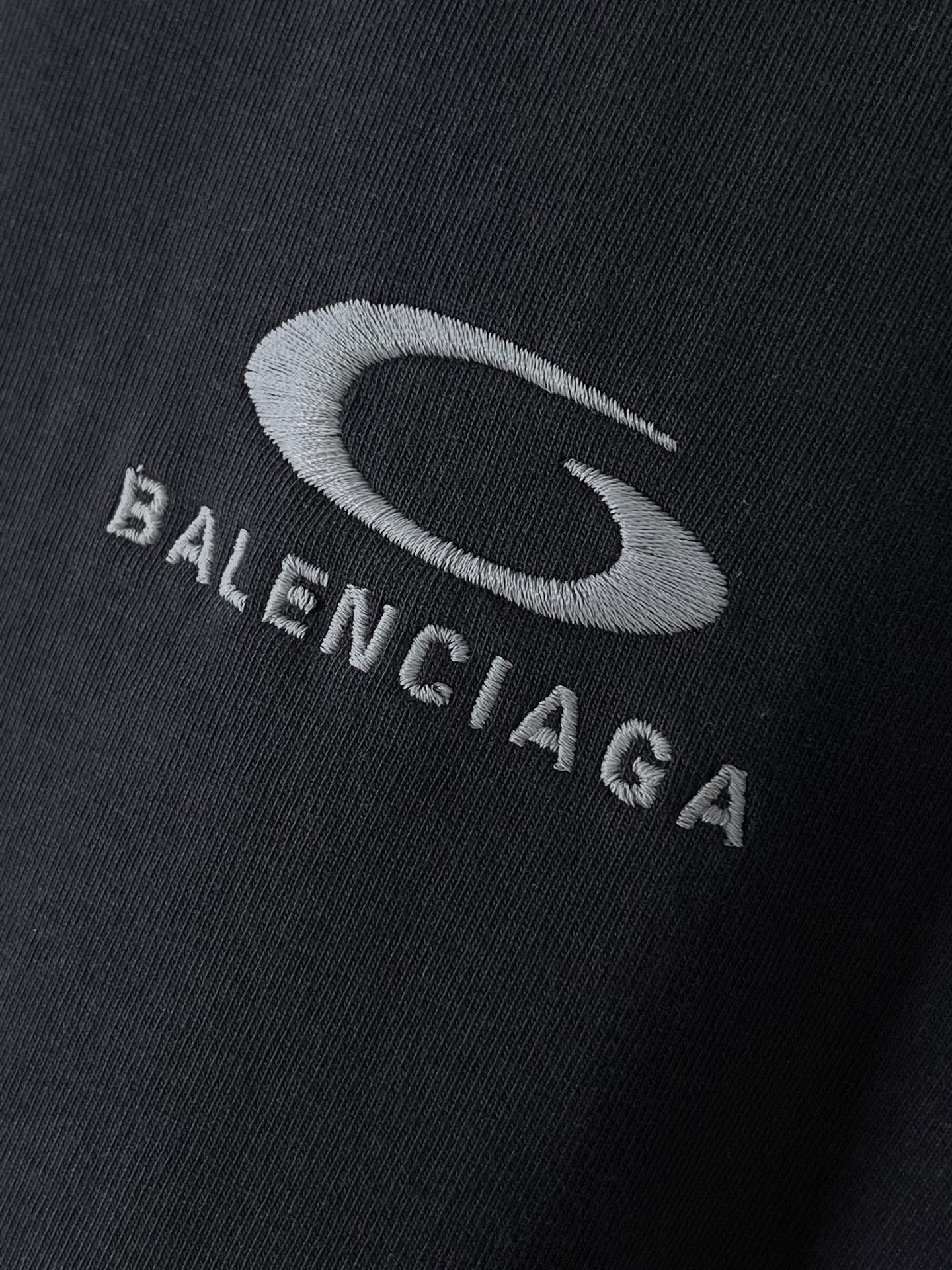 BALENCIAGA logo print on dark T-shirt fabric close-up