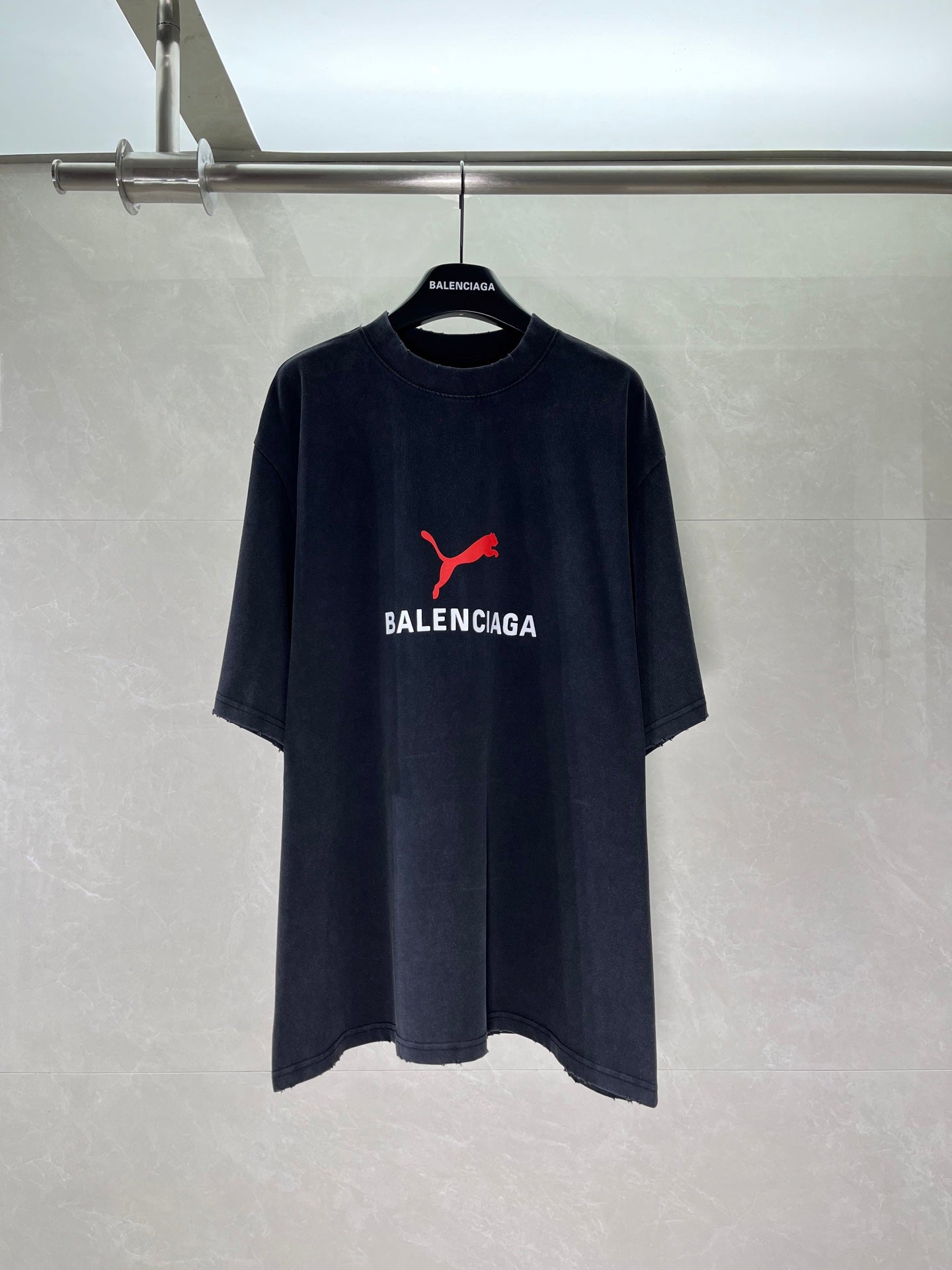 Dark navy short-sleeve T-shirt with red puma-style logo and BALENCIAGA chest print