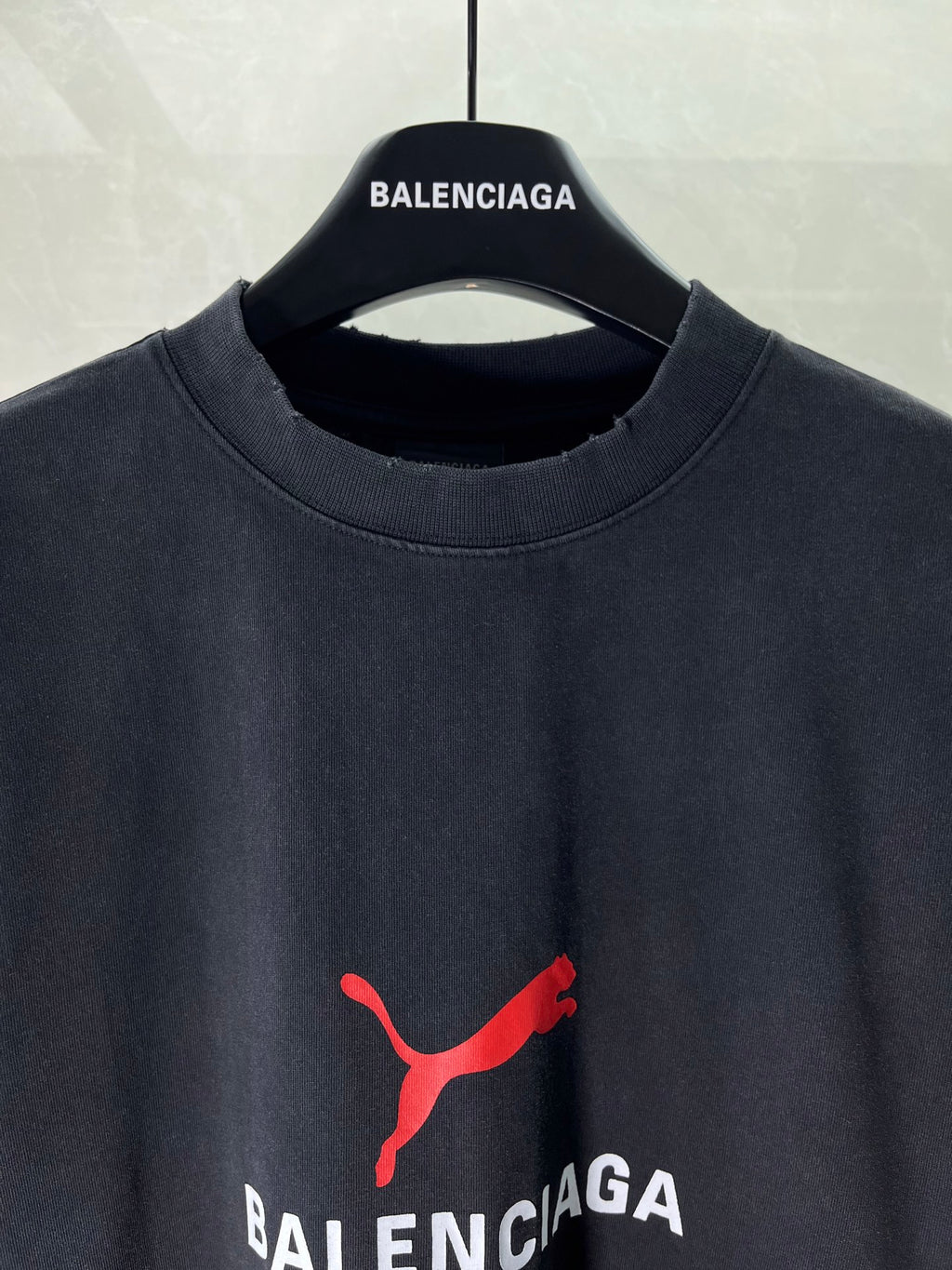Dark navy T-shirt neckline with red puma-style logo and BALENCIAGA text