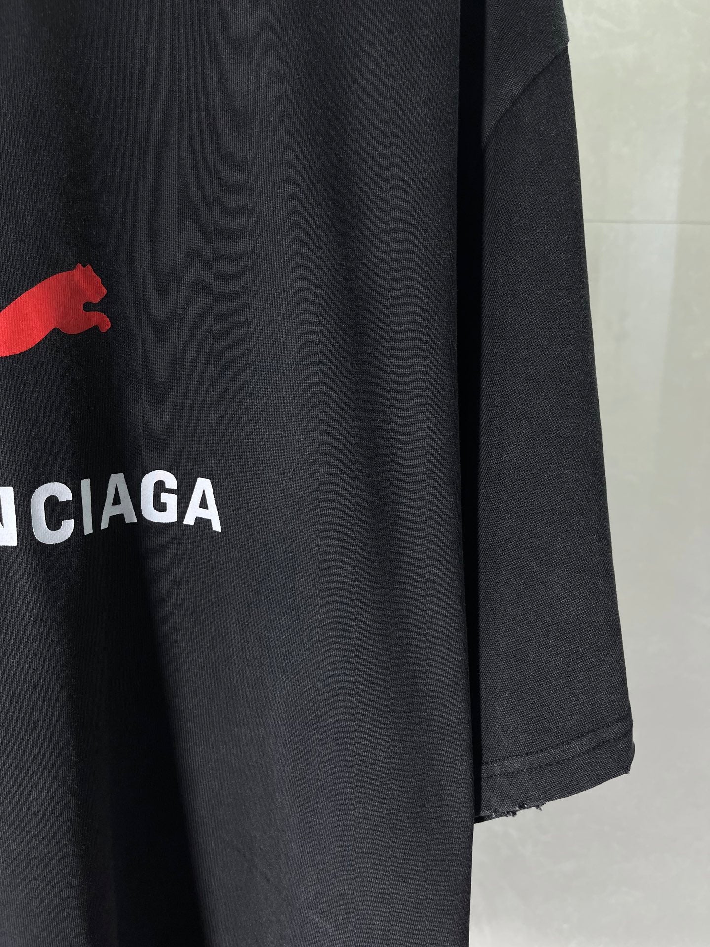 Dark navy T-shirt sleeve and hem with partial BALENCIAGA logo print
