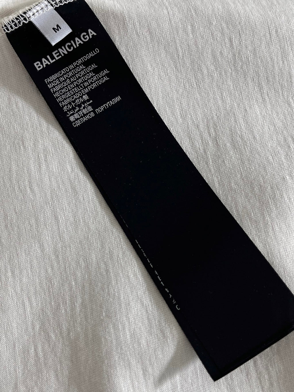 Black product label with size M on Balenciaga T-shirt