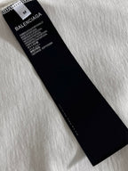 Black product label with size M on Balenciaga T-shirt