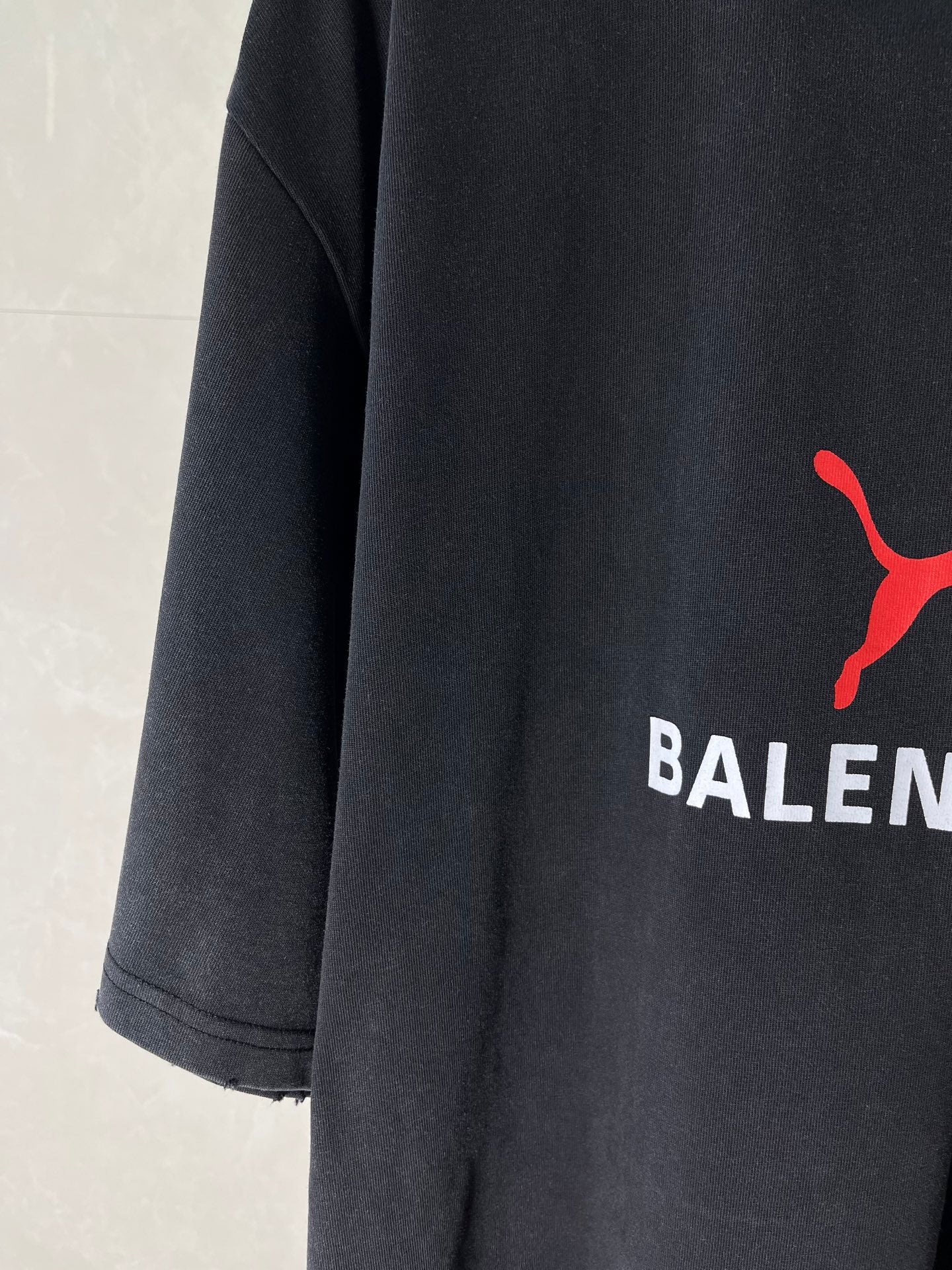 Dark navy short-sleeve T-shirt with partial red puma-style logo on the chest