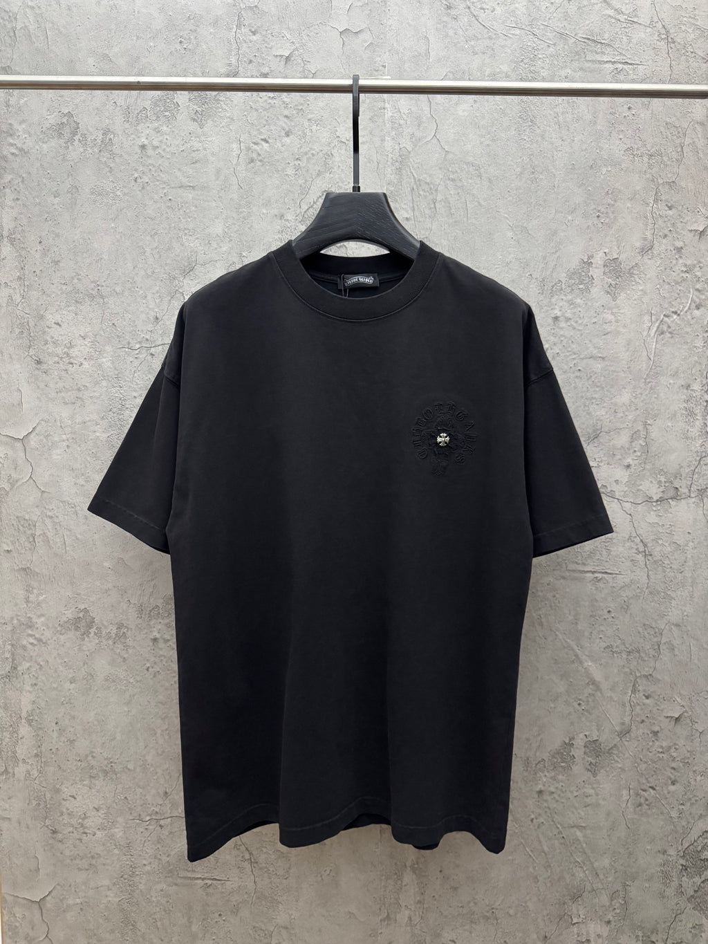 Black short-sleeve T-shirt with small chest logo and crew neck.