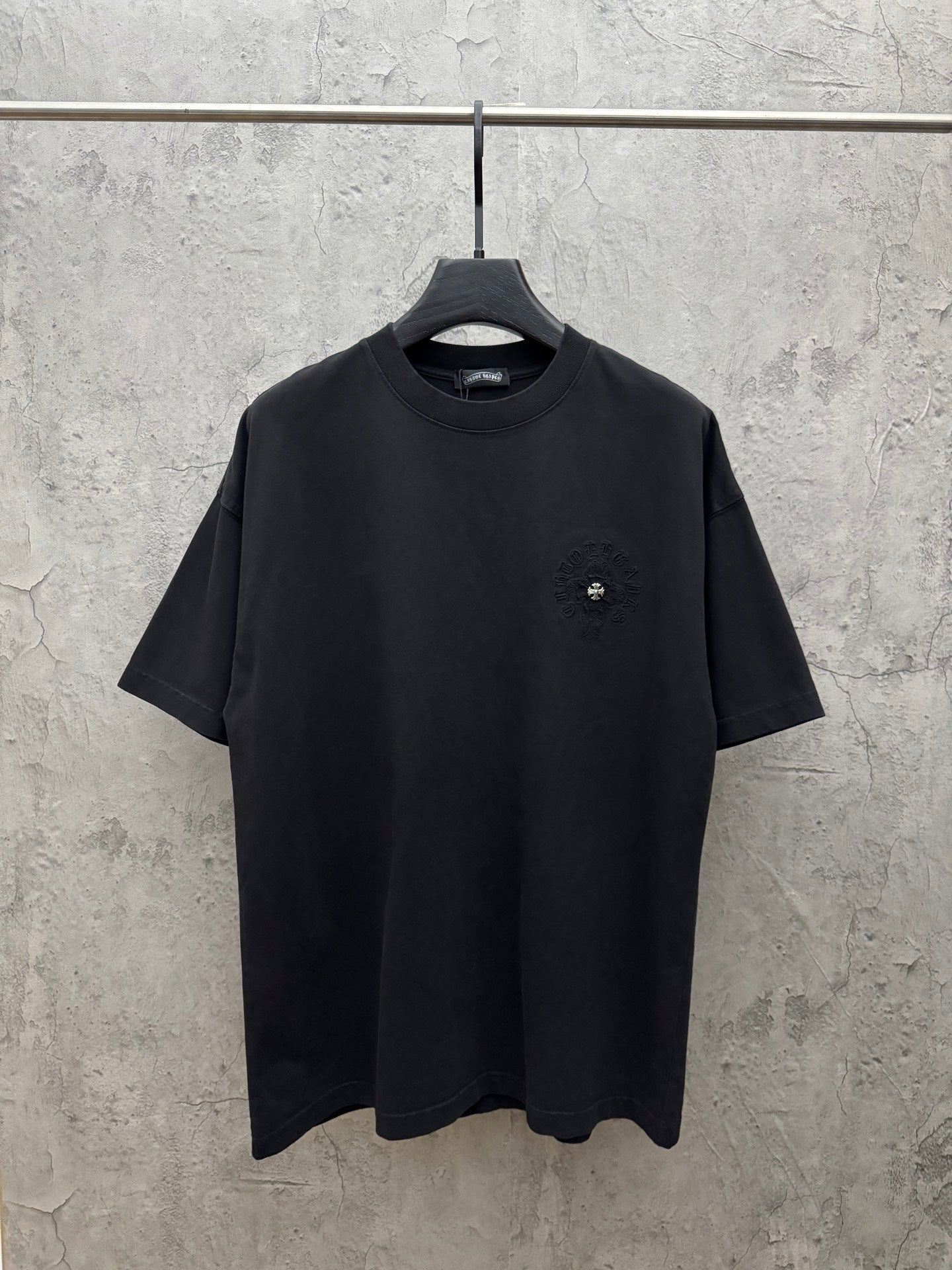 Black short-sleeve T-shirt with small chest logo and crew neck.