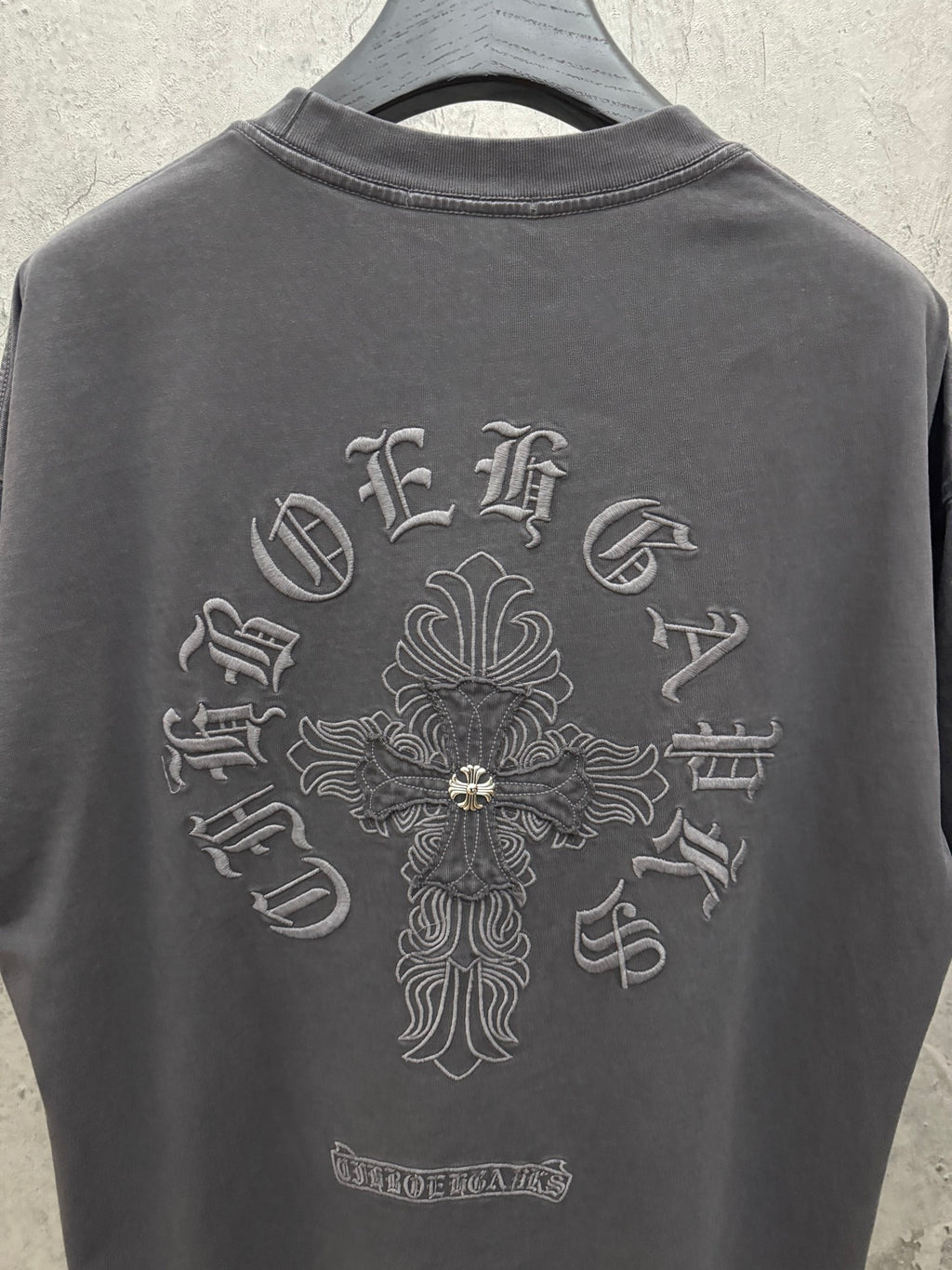 Dark gray crewneck T-shirt with large back cross emblem and small lower label