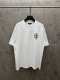 White crewneck T-shirt with small colorful cross graphic on the chest