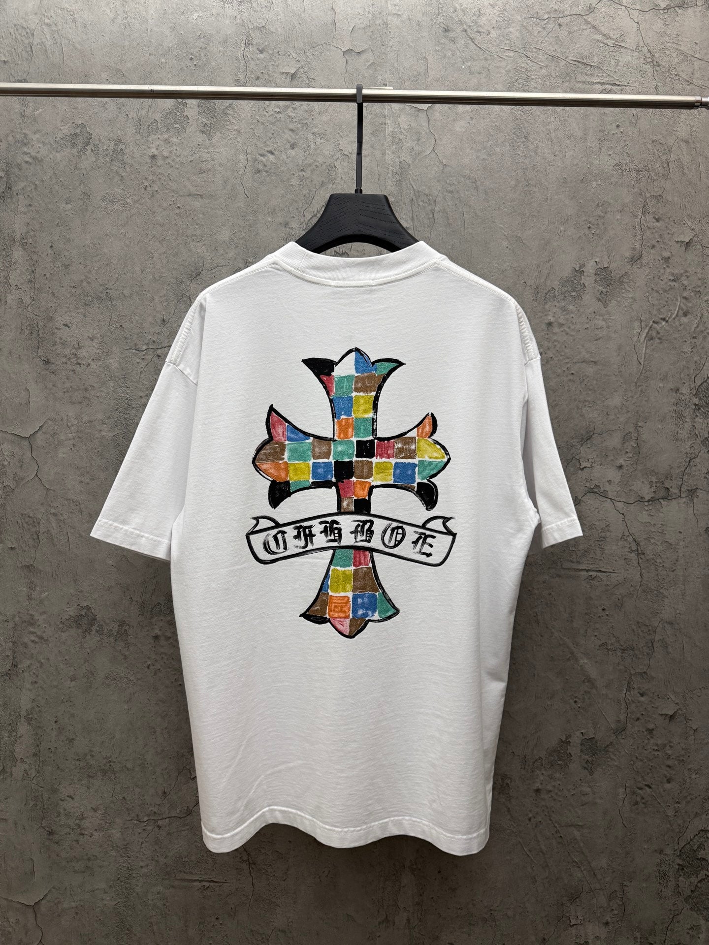 White crewneck T-shirt with large colorful cross graphic on the back
