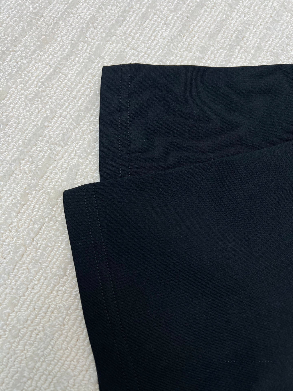 Black T-shirt sleeve and hem stitching detail