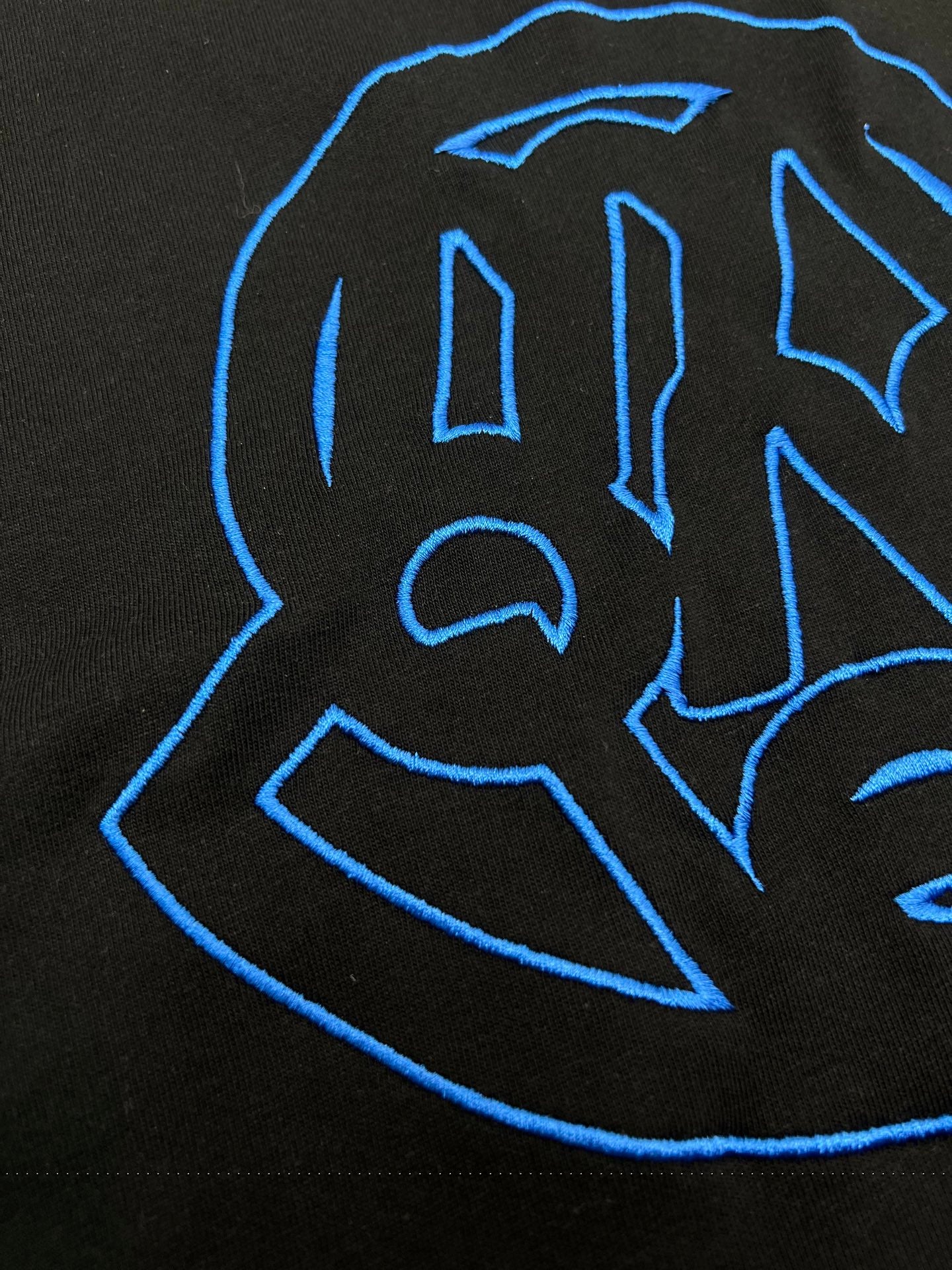 Black T-shirt close-up of blue outline logo graphic