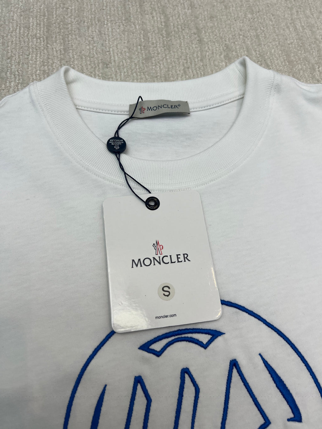 White T-shirt front with Moncler neck tag and blue graphic
