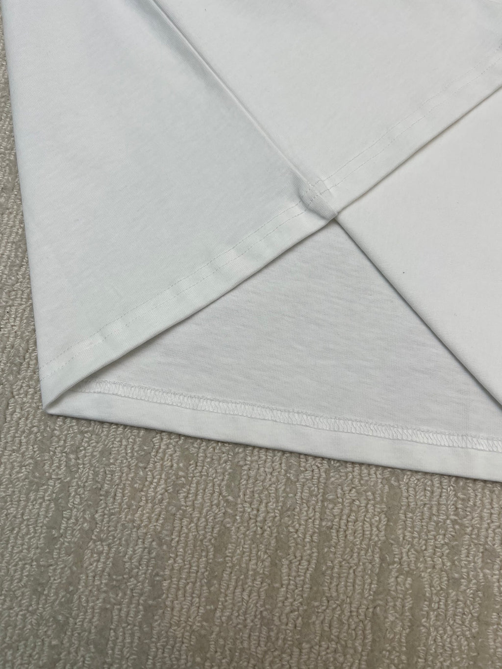 White T-shirt V-fold hem corner with visible seam stitching