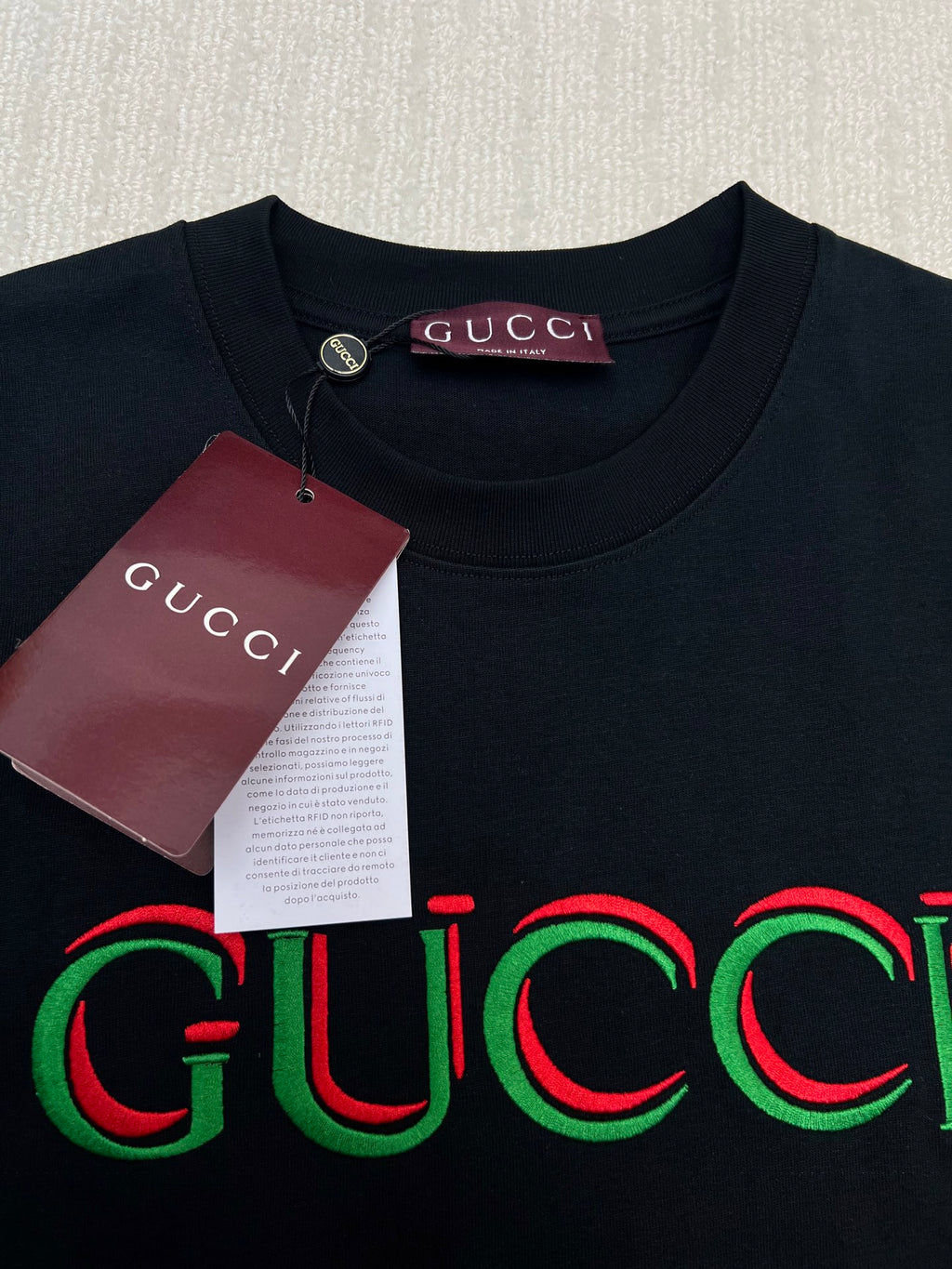 Black Gucci T-shirt with multicolor Gucci logo; round neckline close-up
