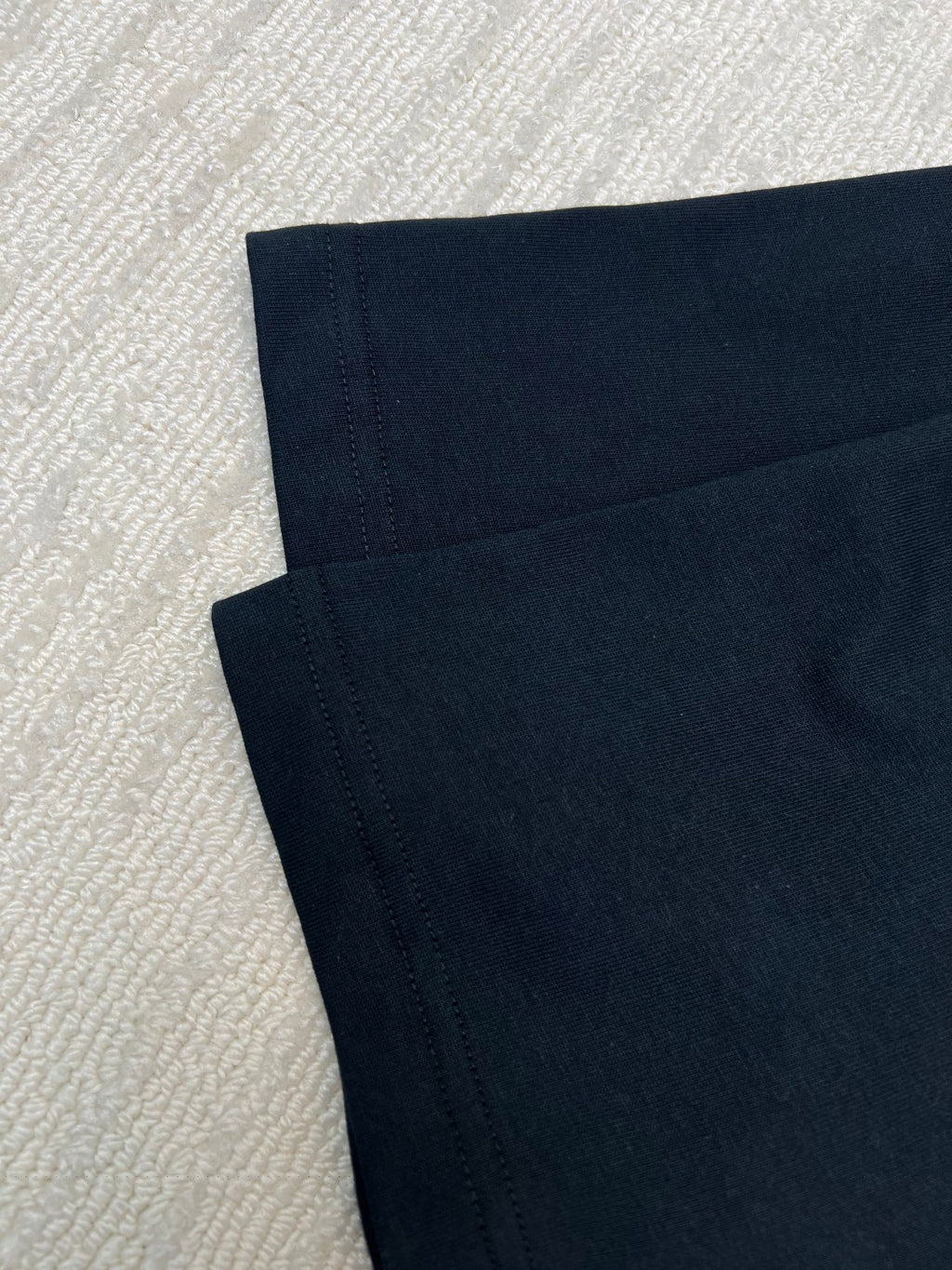 Black short-sleeve T-shirt fabric, seam lines visible