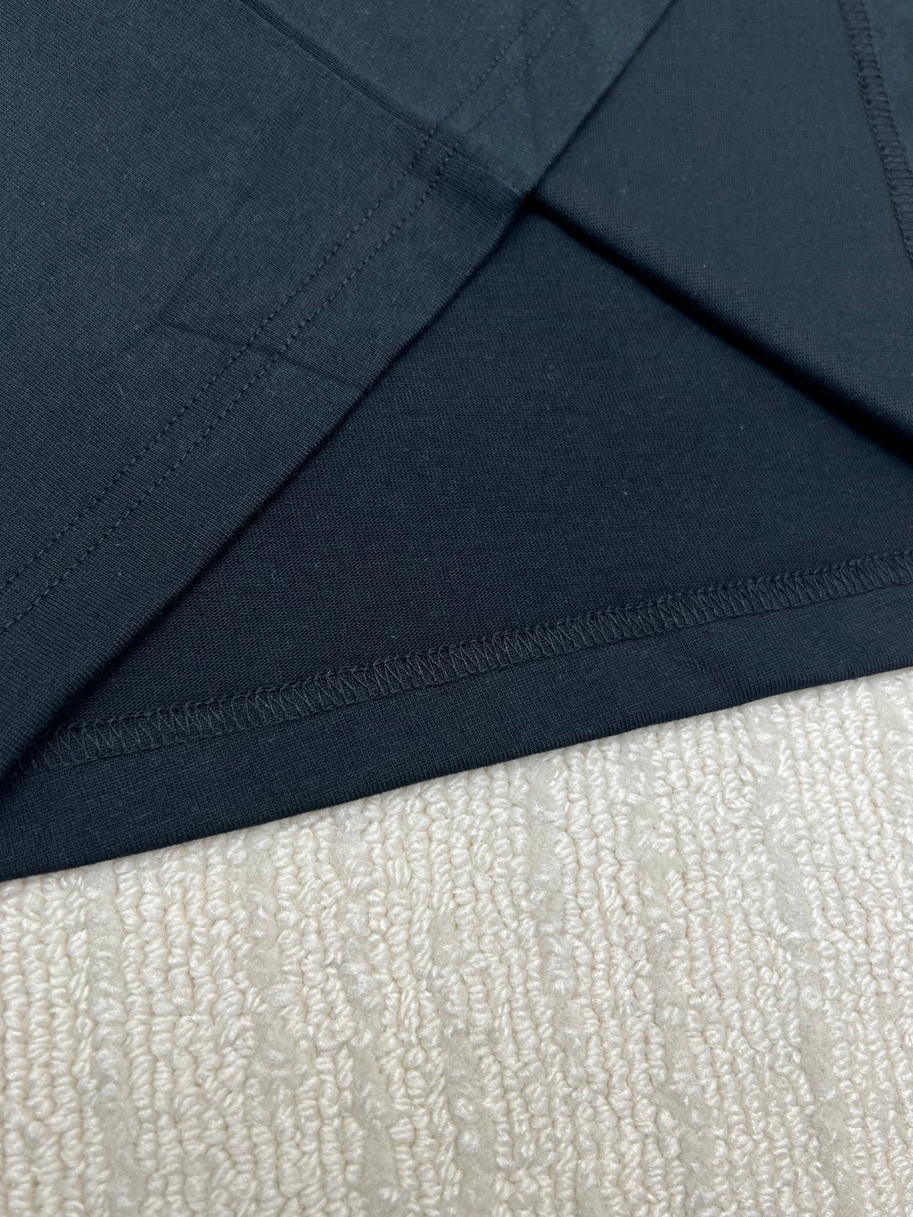 Black T-shirt hem and neckline seam detail