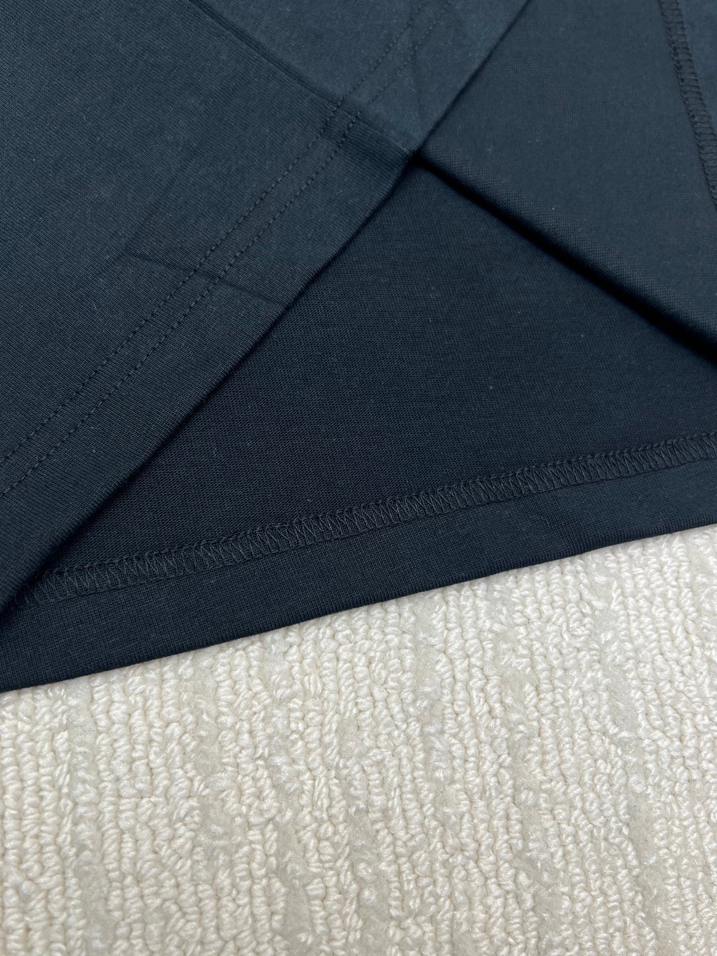 Black T-shirt hem and neckline seam detail