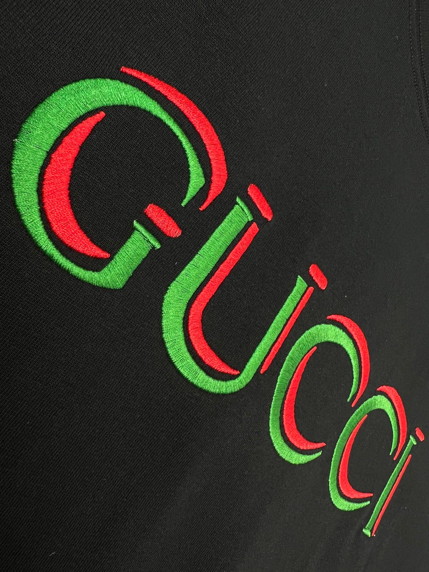 Black Gucci T-shirt close-up of multicolor Gucci lettering