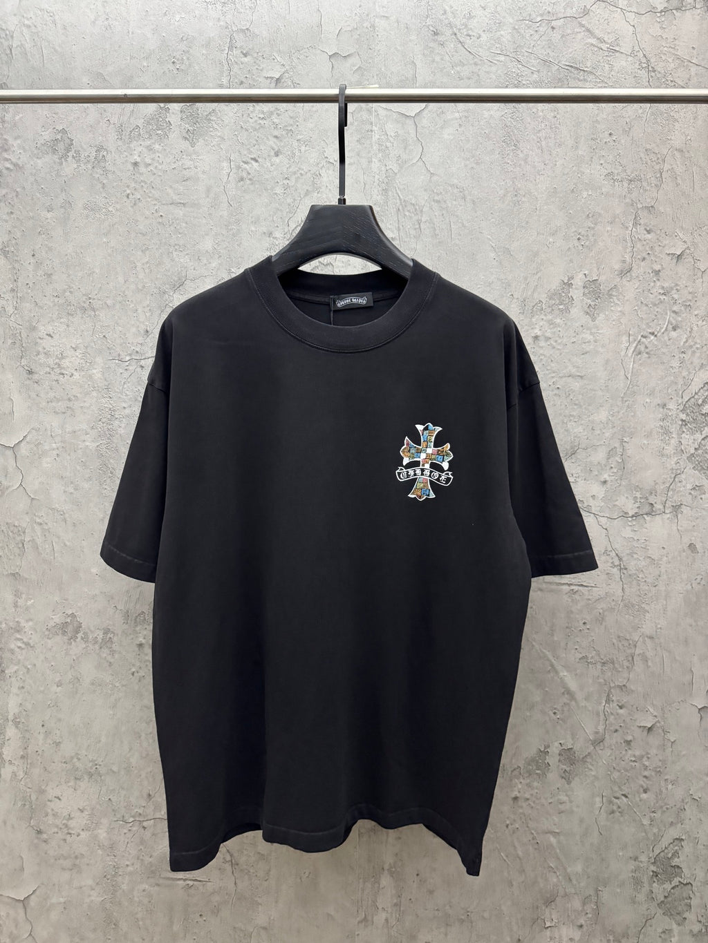 Black short-sleeve T-shirt with small multicolor cross chest graphic