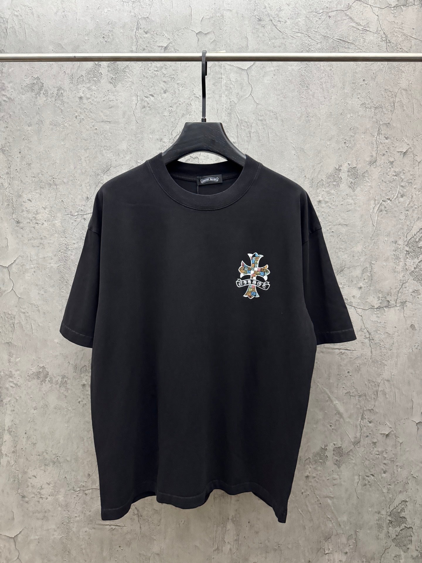 Black short-sleeve T-shirt with small multicolor cross chest graphic