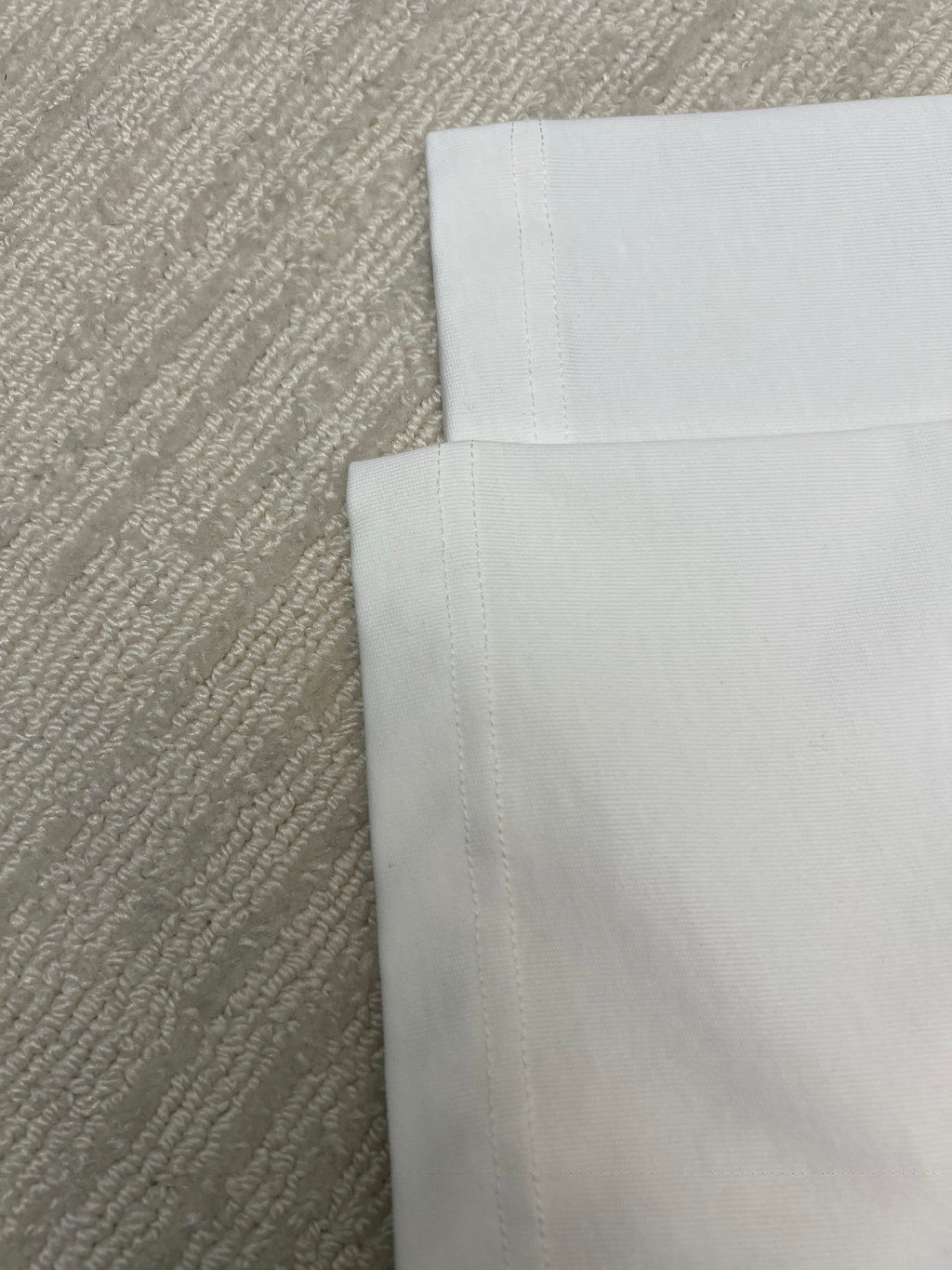 Folded white T-shirt fabric, showing inner side panels