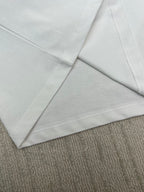 Close-up of white T-shirt with stitched sleeve and hem seams