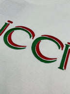 Close-up of white Gucci T-shirt with multicolor Gucci logo letters