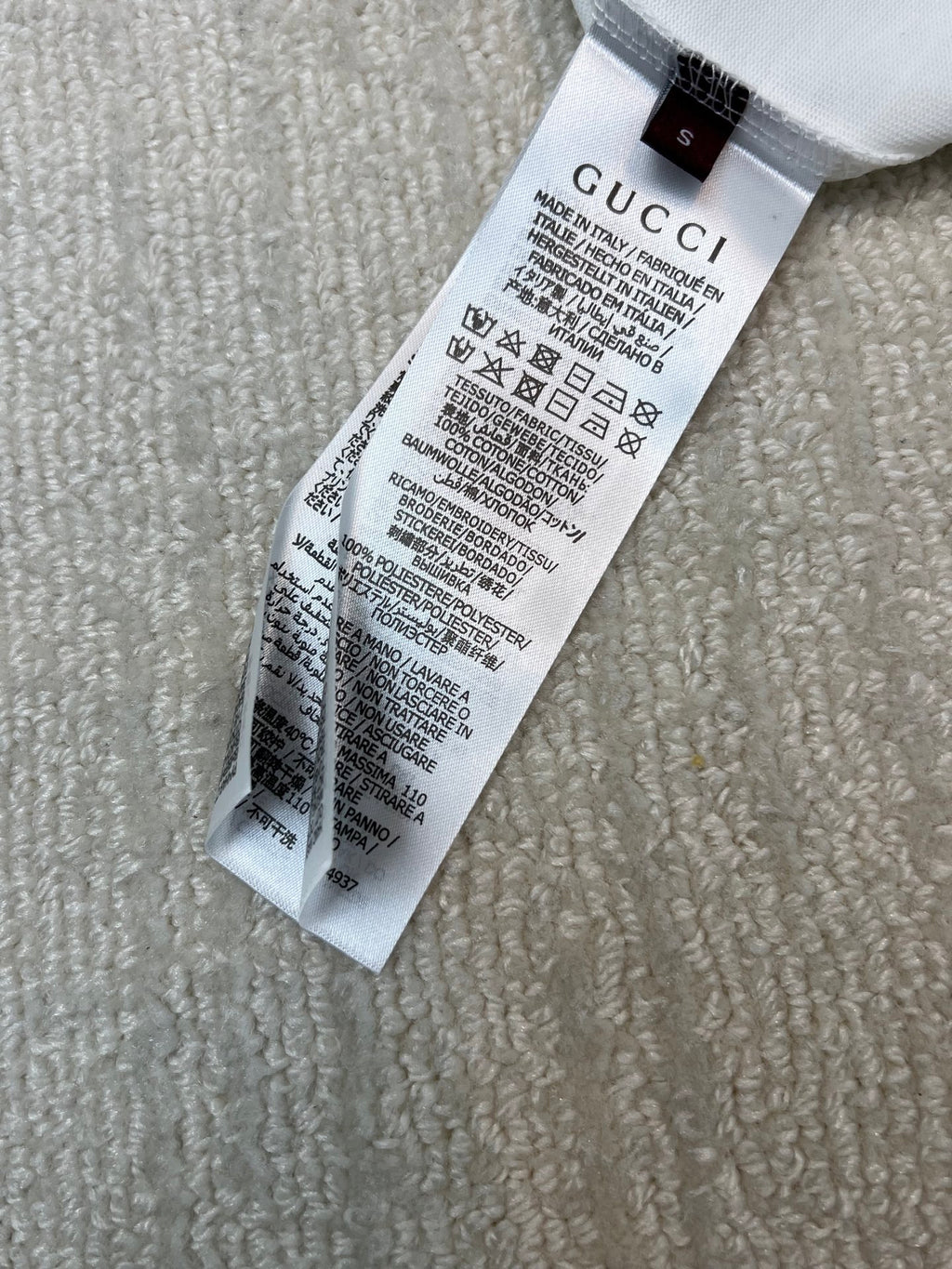 Gucci care label on white T-shirt hem, with washing instructions