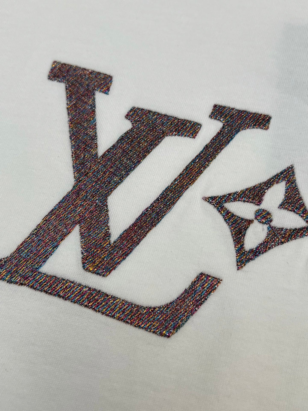 Close-up of large LV logo letters on white T-shirt