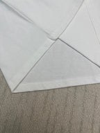 White T-shirt hem and seam detail, crossed fabric fold