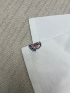 Close-up of Moncler logo patch on white T-shirt sleeve cuff
