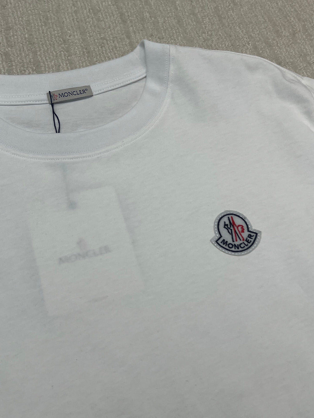 White Moncler T-shirt close-up, round neck and chest logo patch