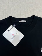 Black crew-neck T-shirt with Moncler logo patch and hanging size tag