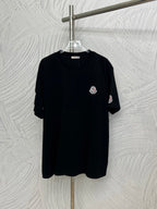 Black short-sleeve T-shirt with small round Moncler logo patch on chest