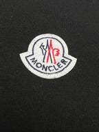Round Moncler logo patch on black T-shirt fabric