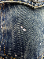 Denim jacket chest pocket with two metal buttons and speckled finish