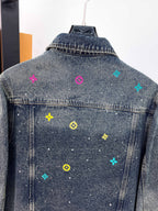 Denim jacket back panel with multicolor symbols scattered across the denim