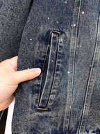 Denim jacket pocket detail with stitched rectangular flap and metal button