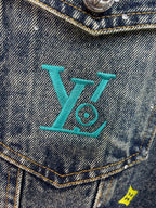Denim jacket chest pocket with turquoise LV-style logo embroidery and studs