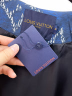 Blue jacket hang tag and Louis Vuitton label on fabric