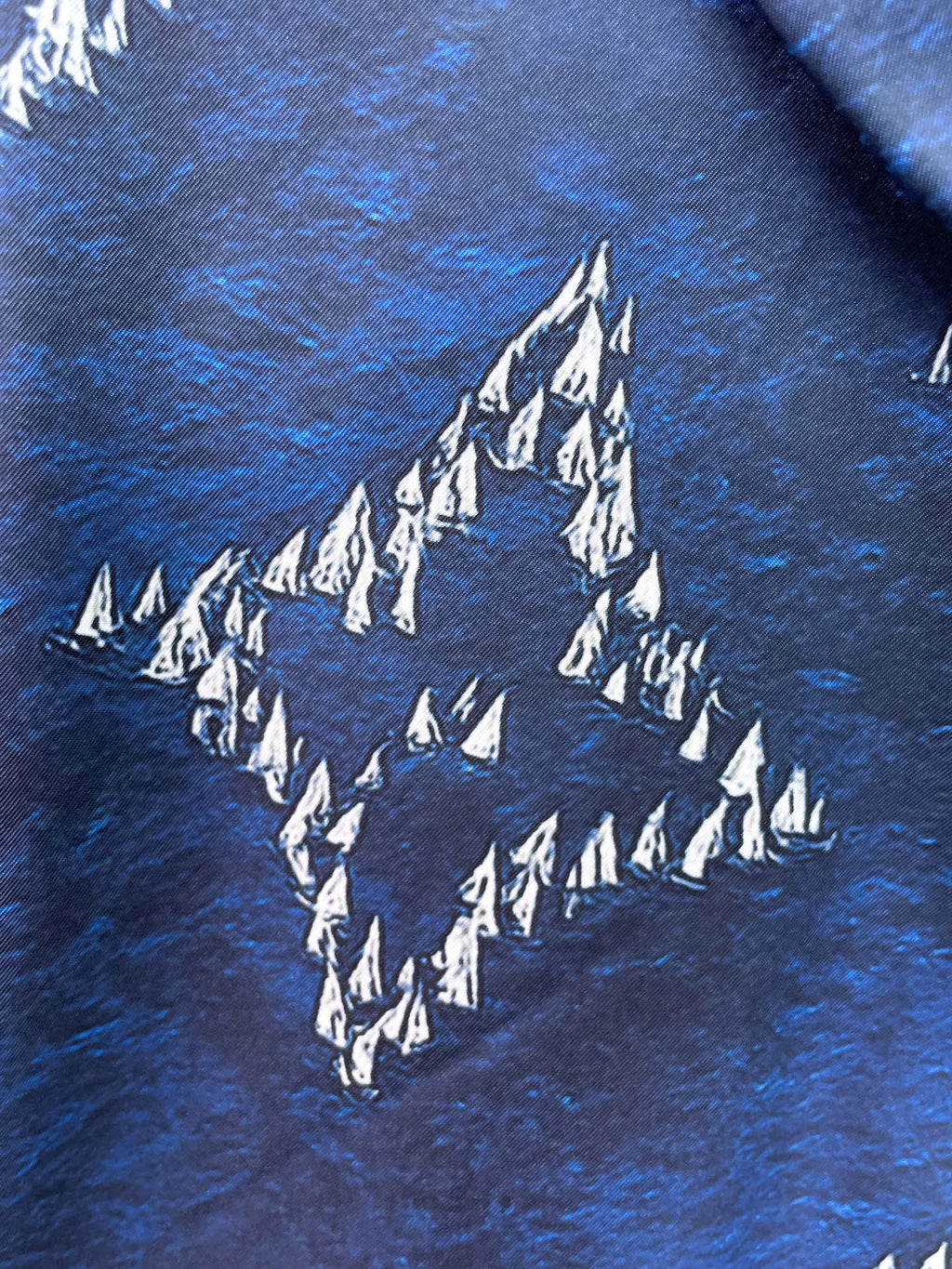 Close-up of blue fabric with white tree and diamond pattern