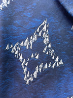 Close-up of blue fabric with white tree and diamond pattern