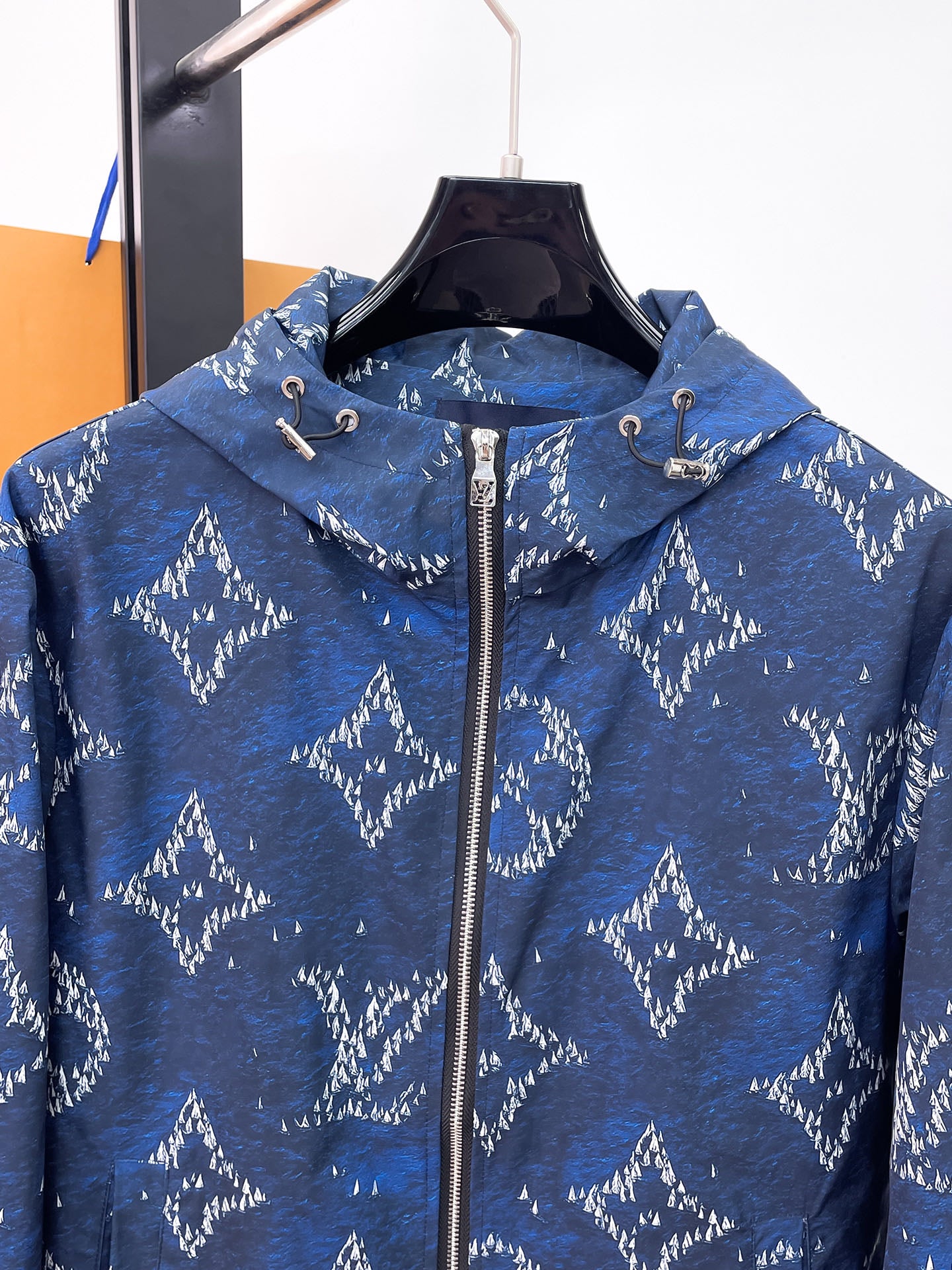 Blue zip-up hooded jacket with white tree print and drawcord collar