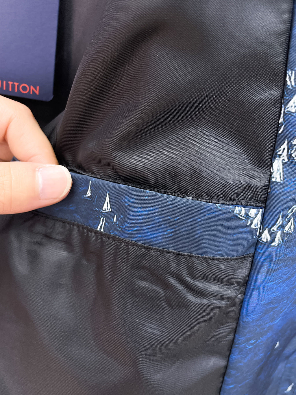 Black inner lining at jacket hem with blue outer fabric