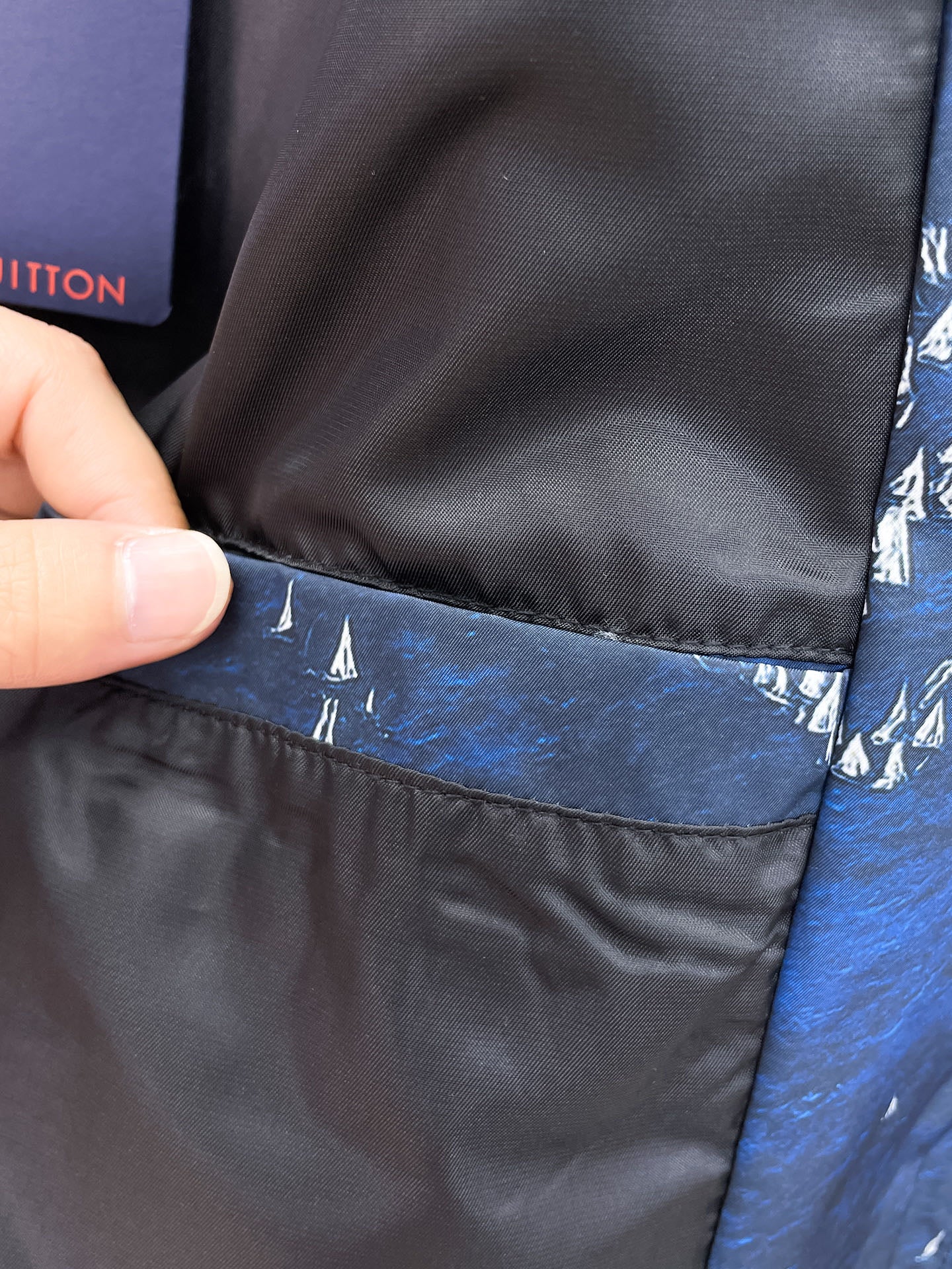 Black inner lining at jacket hem with blue outer fabric