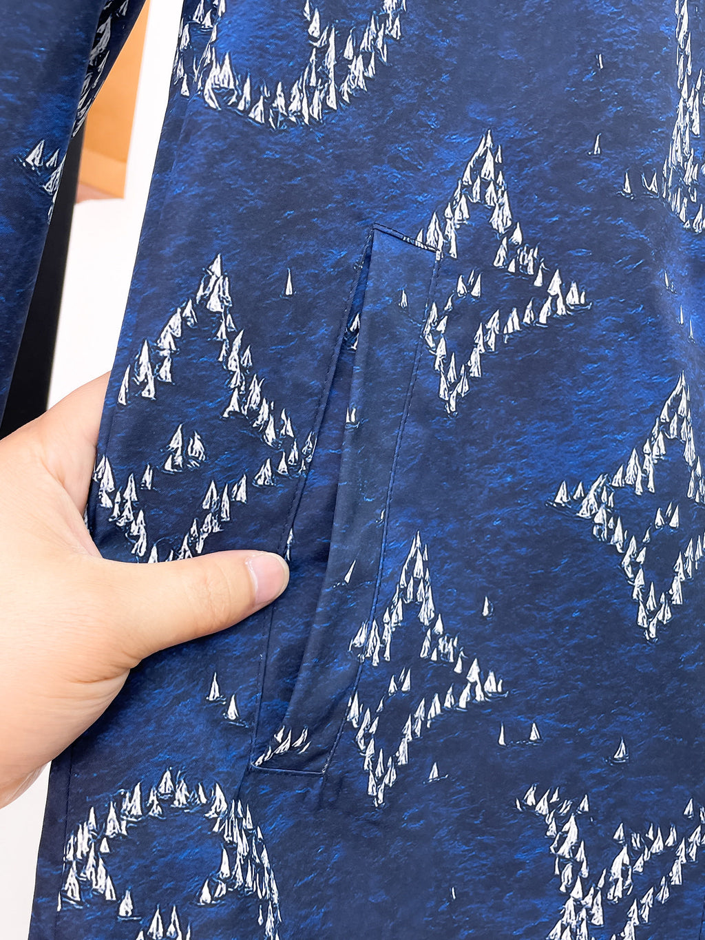 Blue patterned jacket fabric with white tree silhouettes