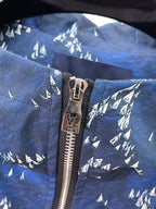 Close-up of blue jacket zipper with white tree print
