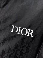 Dior hooded jacket detail, DIOR logo on dark patterned fabric